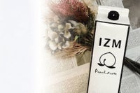 花と並べたIZM ピーチテイストの紙パック