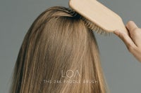 LOA THE 24K PADDLE BRUSHを頭頂部の髪に当ててブラッシングする様子